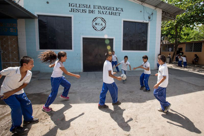 A group of children play soccer at their child development center