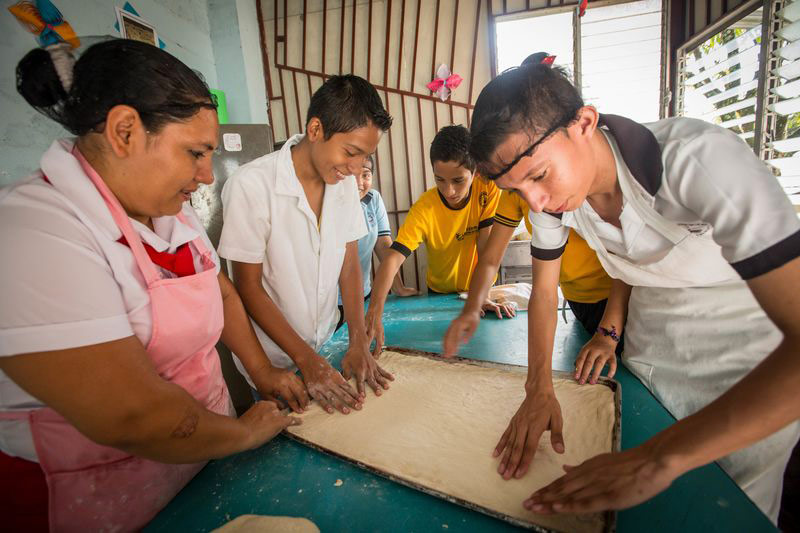 Young adults learn income-generating skills, like baking, at their child development center