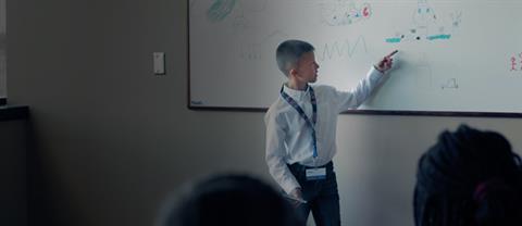 A child gives a presentation on a white board