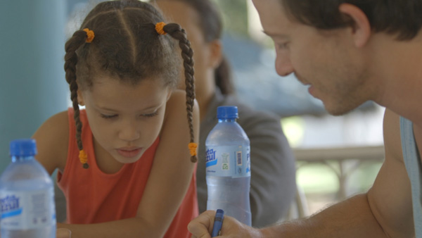 Mike Donehey (Lead Vocal) coloring with his sponsored Child in the Dominican Republic.