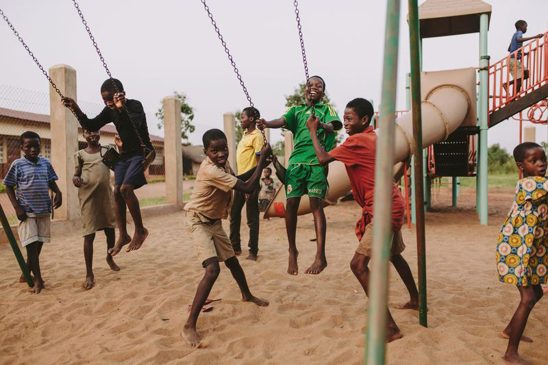 A group of children play joyfully on a playground