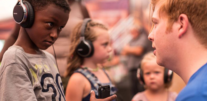 Young kids listening to the Compassion Experience on headphones