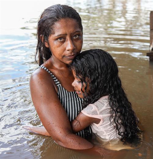 Woman holding her child in the midst of a disaster