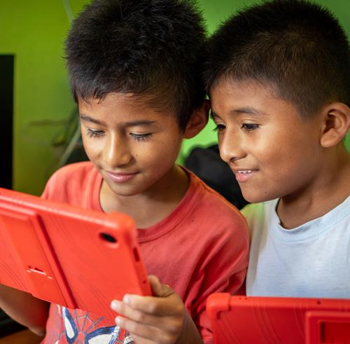 Two boys looking over a tablet