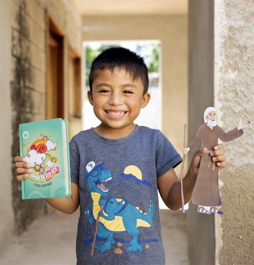 A young boy holding his Bible and craft