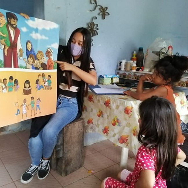 A teacher from the center shares a Bible story during a home visit