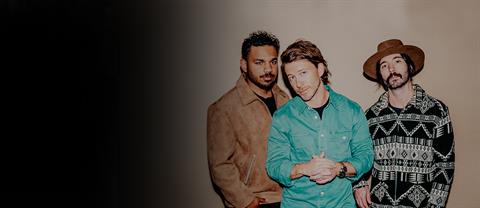 The members of Tenth Avenue North standing together in front of a wall with a beige background.