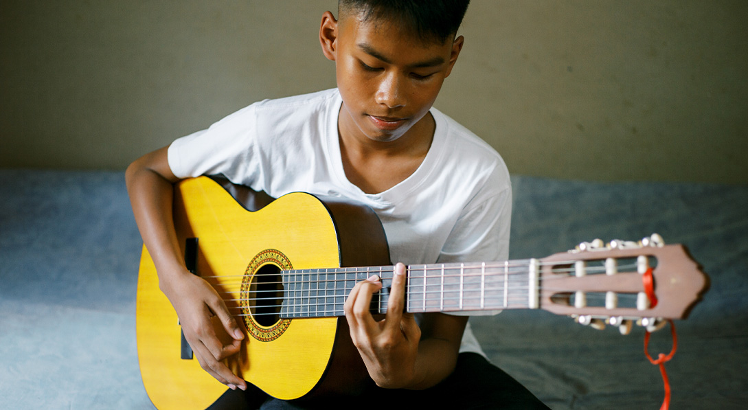 Agung from Indonesia enjoys playing the guitar.