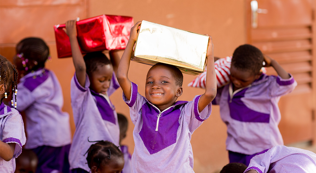 children hold gifts on top of their heads