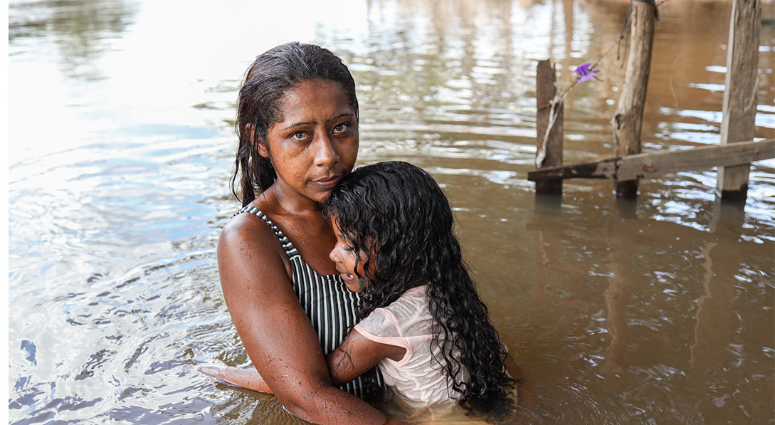 girls hug each other amidst flood
