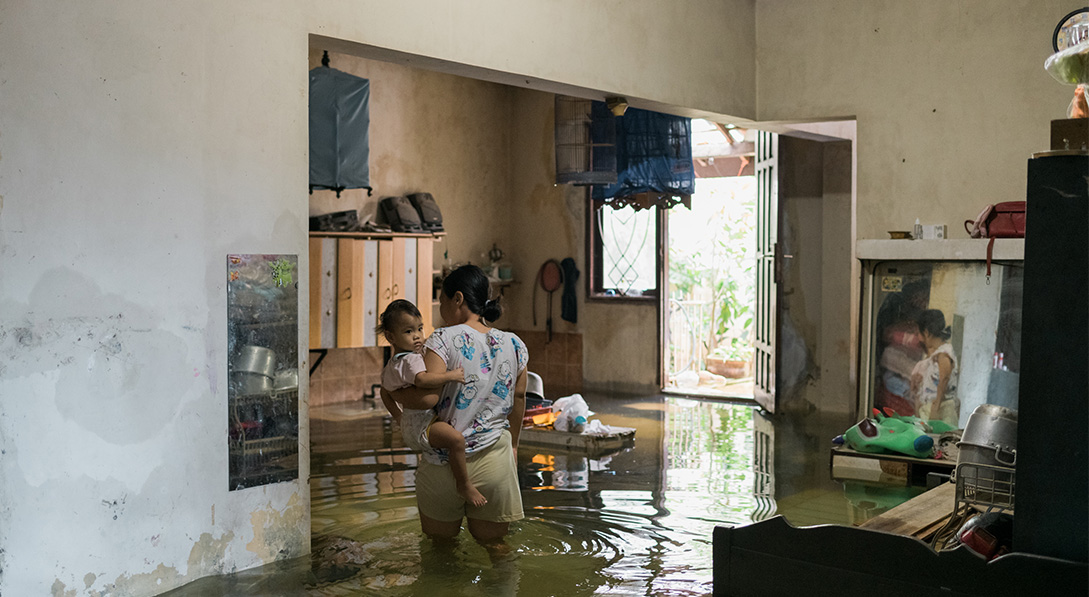 lady stand in flood holding child