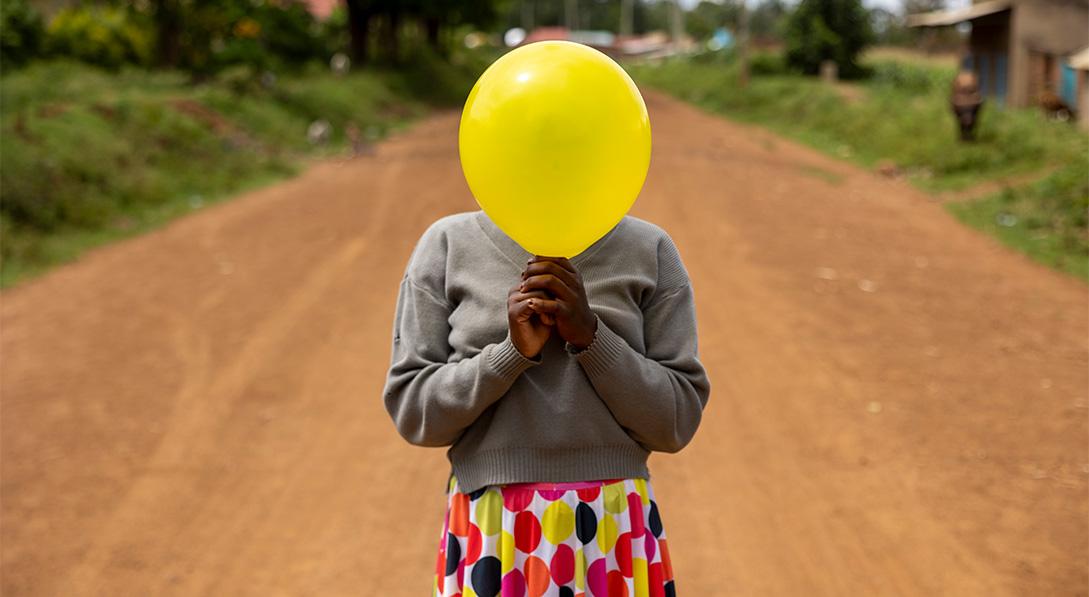 girl holds yellow balloon