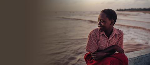 A child in Kenya sits by the water