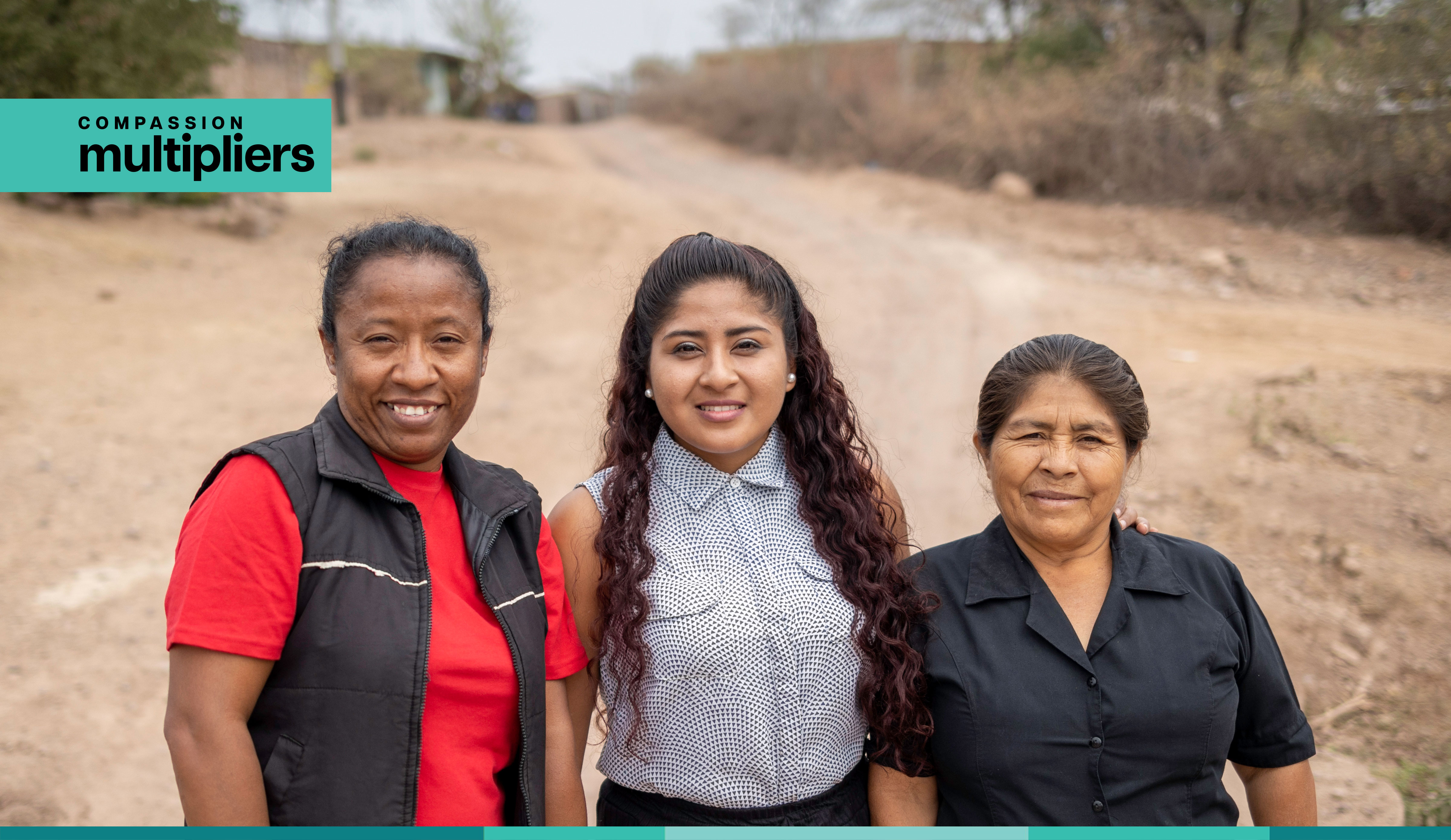 Three ladies smile at camera