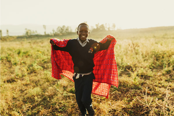 Young boy holding up a blanket